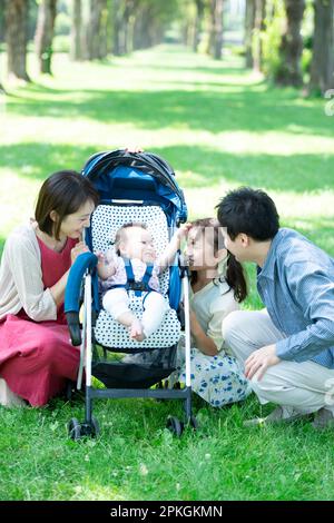 Eltern und Kinder beobachten das Baby im Kinderwagen Stockfoto