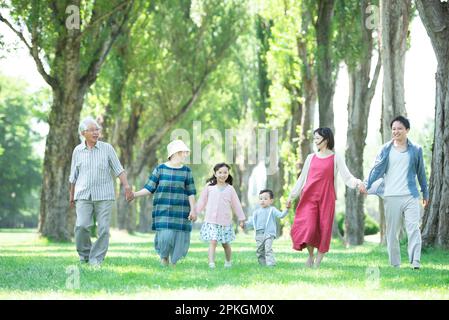 Eine dreiköpfige Familie, die entlang der Pappelallee spaziert Stockfoto