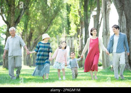 Eine Familie von 3 Generationen, die auf Pappelbäumen spaziert Stockfoto