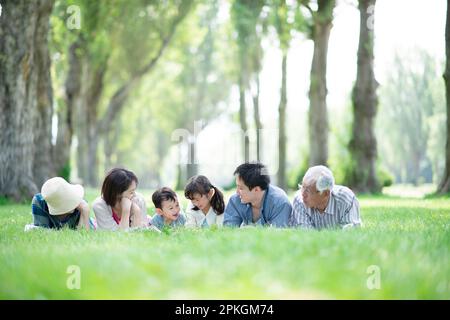 Eine Familie von drei Generationen, die auf der Pappelallee lag Stockfoto