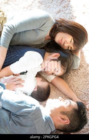 Familie auf dem Teppich liegend Stockfoto