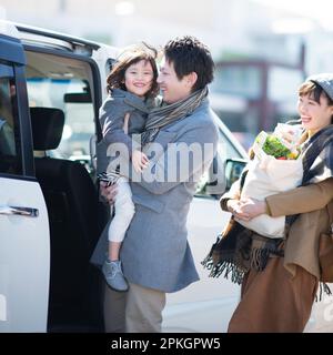 Die Familie unterhält sich am Auto Stockfoto