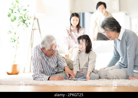 Eine 3-Generationen-Familie, die ein Bilderbuch liest Stockfoto