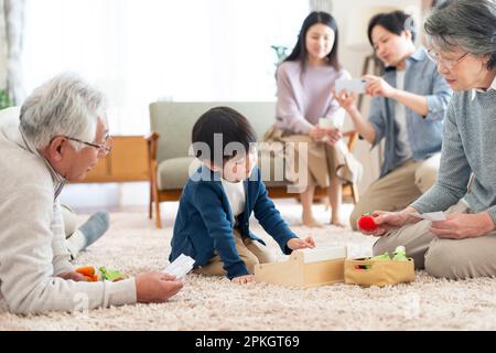 Großeltern und Enkel, die mit Spielzeug spielen Stockfoto