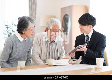 Seniorenpaar spricht mit Geschäftsmann Stockfoto