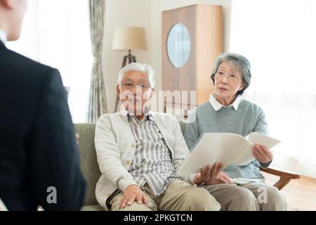 Seniorenpaar spricht mit Geschäftsmann Stockfoto