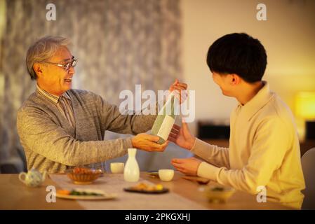 Ein Vater erhält ein Sake-Geschenk von seinem Sohn Stockfoto