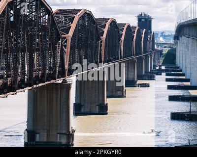 Ein Schnellboot fährt unter Benicia vorbei, der rostigen Eisenbahnbrücke aus Stahl in Kalifornien. Stockfoto