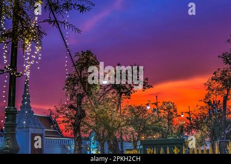 Farbenfroher Sonnenuntergang Saranrom Park Beleuchtete Lichter Sak Chaisit Gate Grand Palace Bangkok Thailand. Palast war die Heimat des Königs von Thailand von from1782 bis 1925. Stockfoto