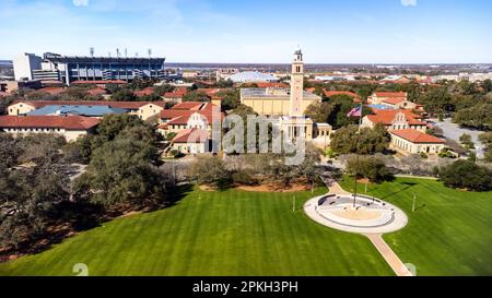 Baton Rouge, LA - Februar 2023: Der Memorial Tower auf dem LSU-Campus ist ein Denkmal für Louisianer, die im Ersten Weltkrieg starben, mit Tiger Stadium und dem Pete Ma Stockfoto