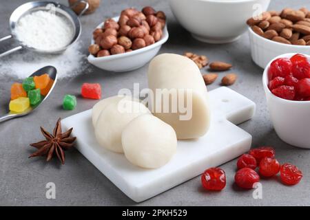 Marzipan und andere Zutaten für hausgemachtes Stollen auf grauem Tisch. Traditionelles deutsches Weihnachtsbrot backen Stockfoto