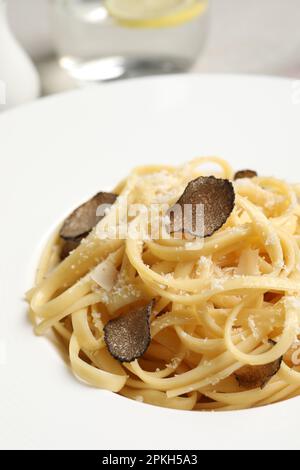 Köstliche Pasta mit Trüffelscheiben und Käse auf dem Teller, Nahaufnahme Stockfoto