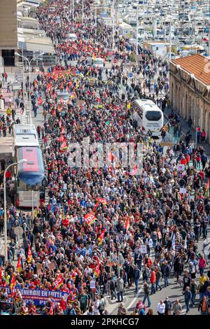 Eine Menge Demonstranten marschiert entlang des Alten Hafens von Marseille mit Flaggen, Bannern und Plakaten, die ihre Meinung während des demonstrationsmarsches 11. gegen die Rentenreform zum Ausdruck brachten. Die französischen Gewerkschaften haben eine 11.-tägige Aktion gegen die Rentenreform der französischen Regierung gefordert, mit der das Rentenalter von 62 auf 64 Jahre angehoben werden soll. Die Polizei schätzt für diesen 11. Tag die Zahl der Demonstranten, die auf den Straßen von Marseille marschieren, auf 10.000, während die Gewerkschaften sie auf 170.000 schätzen. Das Innenministerium meldet 570.000 Demonstranten auf den Straßen Frankreichs, während die Gewerkschaften 2 Mühle beanspruchen Stockfoto