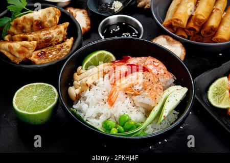 Verschiedene asiatische Gerichte auf schwarzem Hintergrund. Asiatisches Speisenkonzept. Stockfoto
