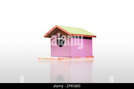 Süßes pinkfarbenes Vogelhaus aus Holz, isoliert auf weißem Hintergrund mit Reflexion, Clipping-Pfad im Preis inbegriffen. Stockfoto