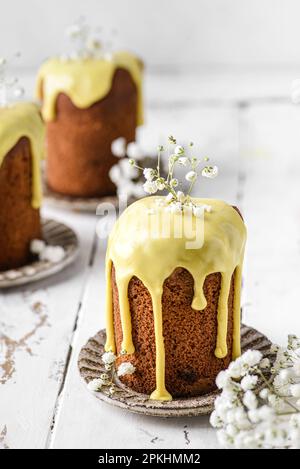 Osterkuchen mit gelber Glasur auf einem Tisch vor einer weißen Wand mit Kopierraum. Hochwertiges Foto Stockfoto