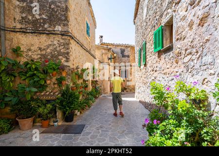 Häuser mit Blumentöpfen dekoriert, Touristen in einer Gasse mit typischen Steinhäusern, Valldemossa, Serra de Tramuntana, Mallorca, Balearen, Spanien Stockfoto