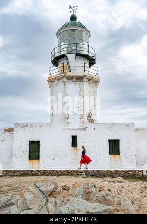 Tourist mit rotem Rock, altem Leuchtturm, Faro De Armenistis, Mykonos, Kykladen, Ägäisches Meer, Griechenland Stockfoto