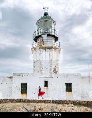 Tourist mit rotem Rock, altem Leuchtturm, Faro De Armenistis, Mykonos, Kykladen, Ägäisches Meer, Griechenland Stockfoto