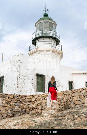 Tourist mit rotem Rock, altem Leuchtturm, Faro De Armenistis, Mykonos, Kykladen, Ägäisches Meer, Griechenland Stockfoto