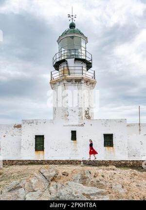 Tourist mit rotem Rock, altem Leuchtturm, Faro De Armenistis, Mykonos, Kykladen, Ägäisches Meer, Griechenland Stockfoto