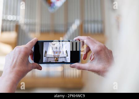 05. April 2023, Niedersachsen, Osnabrück: Blick durch das Display eines Smartphones an der sogenannten Friedensorganisation im protestantischen St. Katharinekirche. Das Gotteshaus hat eine neue Orgel erhalten, die am Ostersonntag in Betrieb genommen wird. Foto: Friso Gentsch/dpa Stockfoto