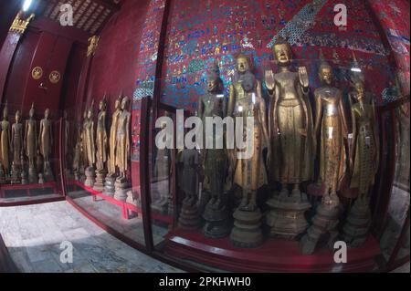 Eine Gruppe antiker Buddha-Bilder verschiedener Größen in der Chariot Hall in Wat Xieng Thong ist eines der schönsten und reichsten Laos. Stockfoto