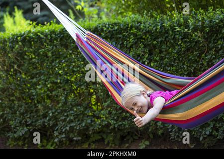 Mädchen (8) in Hängematte im Garten, Kiel, Schleswig-Holstein, Deutschland Stockfoto