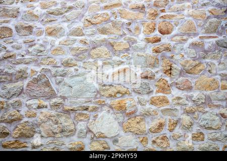Alte Steinwand, leeres Beige mit weißem Zementhintergrund. Grobe Steinwand im Vintage-Stil, blankes Mauerwerk oder Bodenhintergrund. Speicherplatz kopieren. Stockfoto