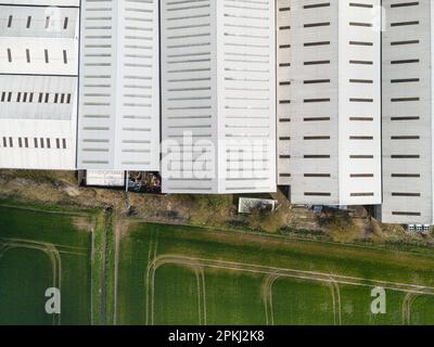 Draufsicht einer großen Lageranlage am Rand eines Ackerfeldes in einem ländlichen englischen Standort. Stockfoto