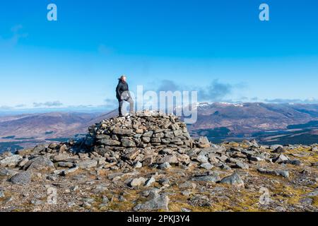 Ein Wanderer am Gipfelkairn des schottischen Munro Berges von Chno Dearg in der Nähe der Spean Bridge, Schottland Stockfoto