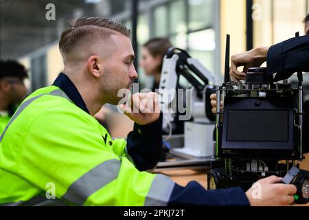 Techniker, die Teile von automatischen Robotermaschinen prüfen und reparieren Stockfoto