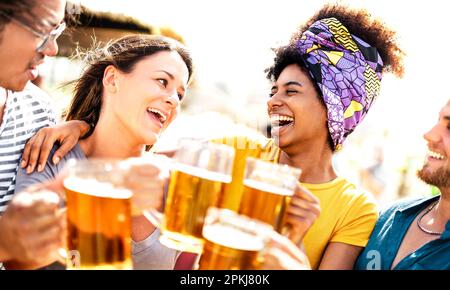 Trendige Multi-Rassenfreunde, die auf der Sommerparty am Strand einen Bären toasten - das Lebensstilkonzept für Speisen und Getränke mit verschiedenen jungen Leuten bei der Einstellung Stockfoto