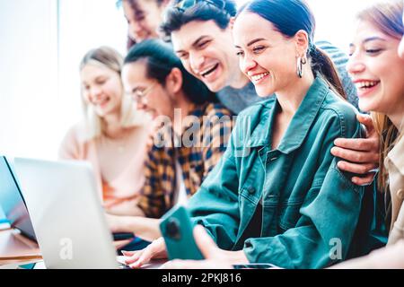 Junge Jahrtausendschülerinnen und Schüler, die Inhalte auf einem Laptop im Startup-Studio teilen – trendige Freunde, Lebensstil und Teamwork-Konzept für die Arbeitszeit im Büro Stockfoto