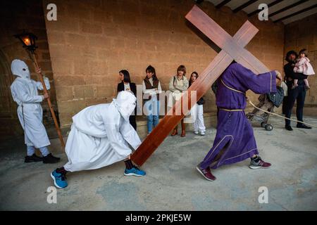 Die Brüder der „Santa de la Vera Cruz“, die in Prozession von der Kirche San Andrès in Torres del Río, Navarra, Spanien, abfahren. Die Bruderschaft der 'Santa de la Vera Cruz' feiert eine charakteristische Prozession in der Heiligen Woche in Torres del Río, Navarra, Spanien, in der die Bußgesellen weiß gekleidet sind und einen kleinen Teil des Camino de Santiago, In dem sie ein Kreuz tragen, in dem eine Buße die Stille der Nacht bricht, indem sie zum Klang der Schritte schlagen, während andere Mitglieder der Bruderschaft die Virgen de la Dolorosa tragen. Stockfoto