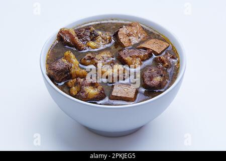 Rawon, indonesische Rindfleischsuppe. Aus Surabaya, Ost-Java. Verwendet die schwarze Nuss Keluak als Hauptwürzmittel, was eine dunkle Farbe ergibt Stockfoto