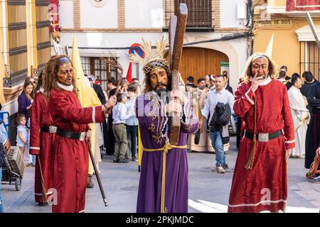 Puente Genil, Spanien. 07. April 2023. Die Hässlichen peitschen den Charakter Jesu Christi, der das Kreuz trägt, während einer Karfreitagsprozession, die Teil der Heiligen Woche ist, oder Semana Santa, 7. April 2023 in Puente Genil, Spanien. Die Stadt hat eine ungewöhnliche Feier mit einer Prozession aller biblischen Figuren seit 1661. Kredit: Richard Ellis/Richard Ellis/Alamy Live News Stockfoto