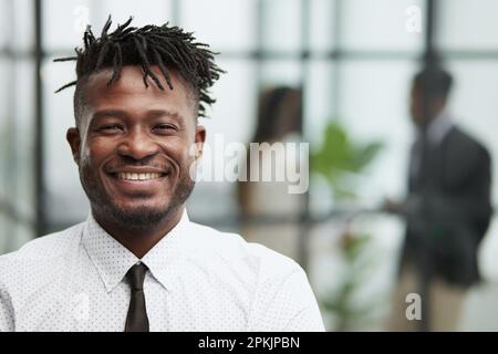 Nahaufnahme eines lächelnden, gutaussehenden afroamerikanischen Geschäftsmanns in einem weißen Hemd Stockfoto