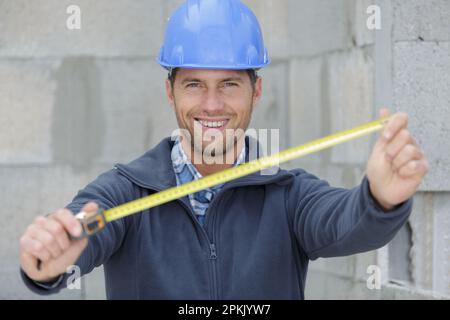 Ein Baumeister, der den Rollenzähler zeigt Stockfoto