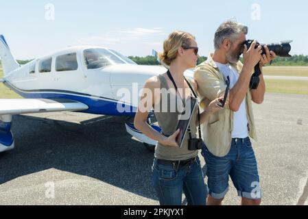 Seniorfotograf, der auf dem Flugplatz fotografiert Stockfoto