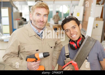 Mann und Lehrling schauen in die Kamera Stockfoto