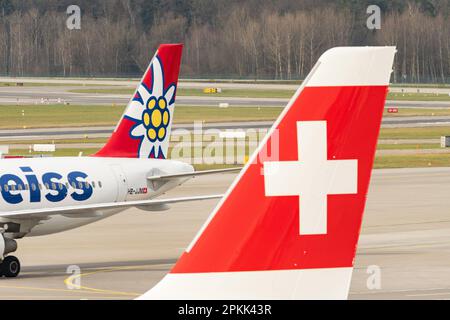 Zürich, Schweiz, 2. Januar 2023 Edelweiss Air Airbus A320-214 hinter dem Schweizer Logo auf dem Ruder eines anderen Flugzeugs Stockfoto