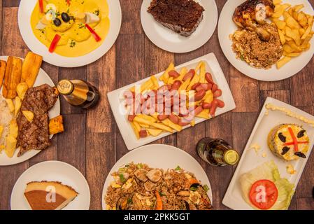 Conjunto de Platos de comida peruana con salchipapas, causa lima, arroz con pollo, quesillo, patatas a la huancaina y cerveza Stockfoto