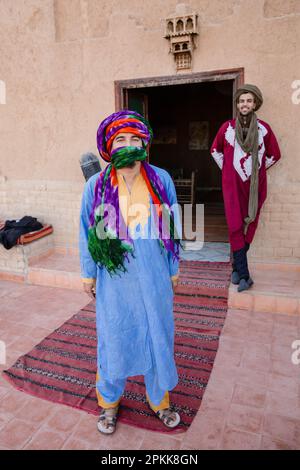 Zwei traditionell gekleidete marokkanische Männer stehen vor einem Gebäude, um Menschen willkommen zu heißen Stockfoto