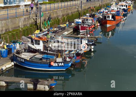Farbenfrohe kleine Fischerboote und Angelausrüstung auf einem Ponton in Brighton Marina. Stockfoto