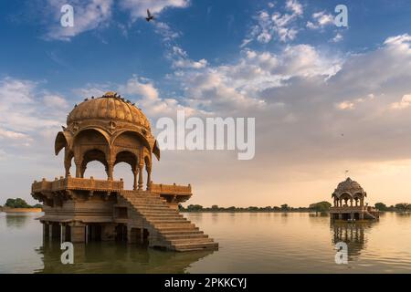 Chhatris und Schreine der hinduistischen Götter und Göttinnen am Gadisar-See, Jaisalmer, Rajasthan, Indien mit Reflexion über Wasser. Indoislamische Architektur. Stockfoto