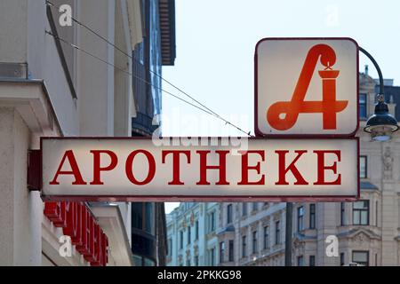 Österreichische Apotheke mit dem Schild für die traditionelle Apotheke über dem zweiten Schild „Apotheke“, was auf Englisch „Apotheke“ bedeutet. Stockfoto