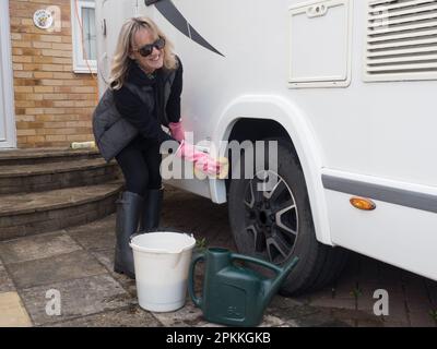 Eine Wohnmobil-Besitzerin wäscht ihr Freizeitfahrzeug mit Eimer Stockfoto