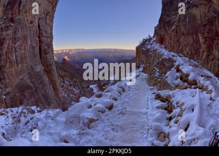 Vom Bright Angel Trail am Südrand direkt hinter dem zweiten Tunnel aus bietet sich im Winter ein Sonnenaufgang auf den Grand Canyon Arizona Stockfoto