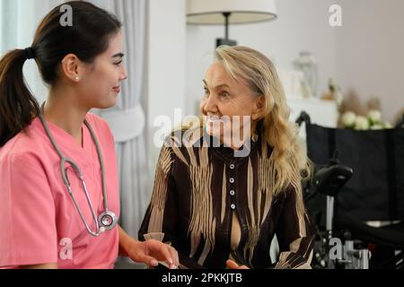 Arztin im Gespräch mit älterer Patientin bei Hausbesuch Stockfoto